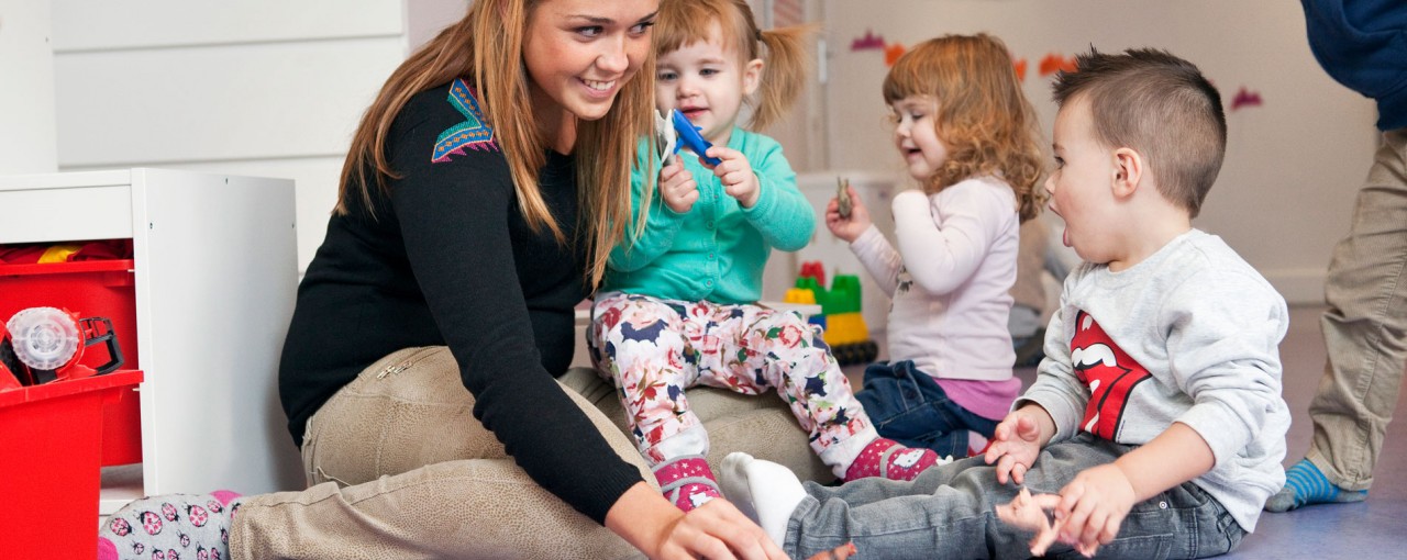 medewerker van een kinderdagverblijf met 3 peuters